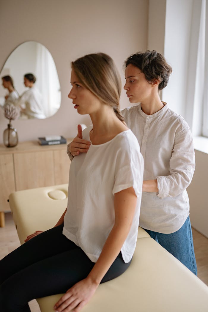 Two women engaging in a therapeutic physical therapy session in a serene indoor setting.